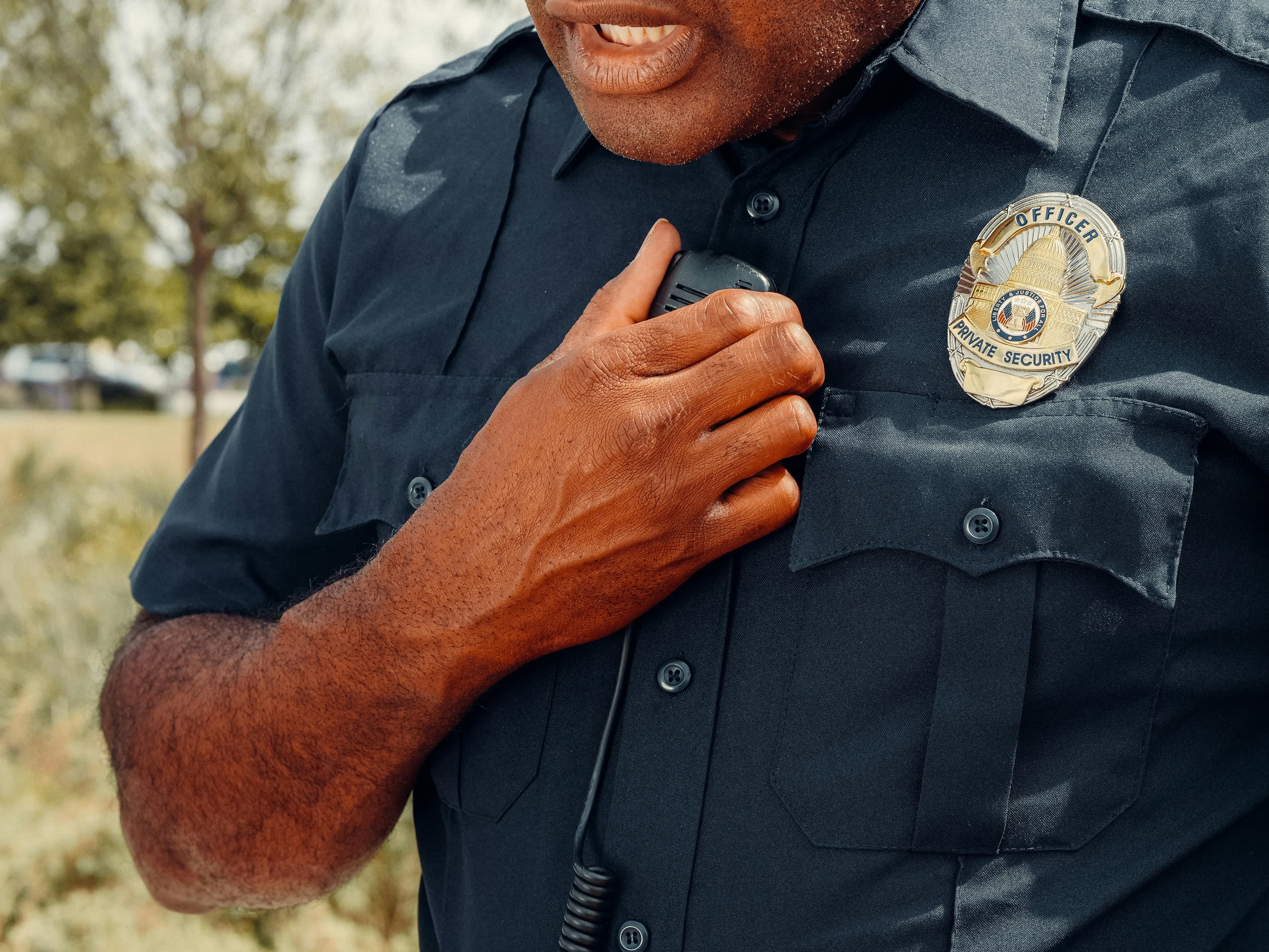 Close-up of a private security officer's badge and radio